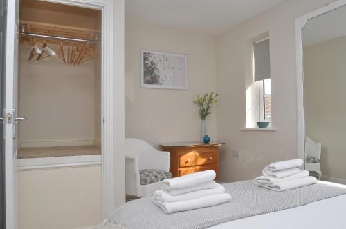 a white bedroom with white towels on a bed at Glebelands in West Monkton