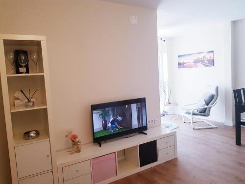 salon z telewizorem z płaskim ekranem w centrum rozrywki w obiekcie PRECIOSO ATICO JUNTO A LA FERIA w mieście Jerez de la Frontera