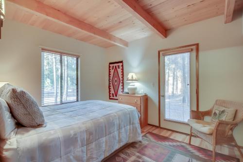 a bedroom with a bed and a chair and windows at 5 Butternut in Sunriver