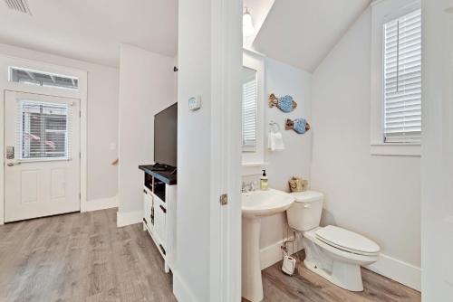 Un baño blanco con inodoro y lavabo. en 3 Bed 4 Bath Vacation home in Barefoot Cottages - Port St. Joe, en Highland View