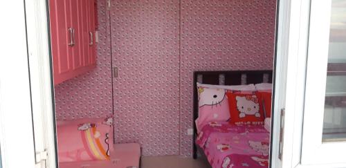 a small bedroom with a bed and a window at Hello Kitty at Wind Residences Tagaytay in Tagaytay