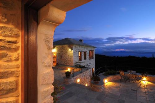 a stone house with a patio at night at Sakali Mansion in Pinakátai