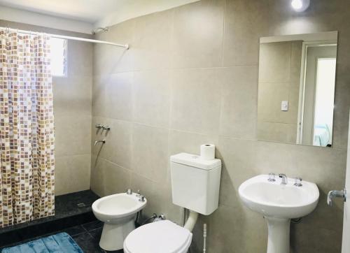 ein Badezimmer mit Toilette, Waschbecken und Spiegel in der Unterkunft Aparts de Montaña Tavullia in Carpintería