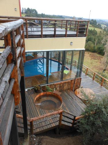 an outdoor deck with a plunge pool on a house at Hotel Parque Quilquico in Castro