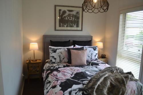 塔南達的住宿－Gone to Barossa，一间卧室配有一张床、两盏灯和一个窗户。