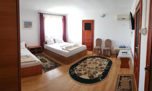 sypialnia z 2 łóżkami, stołem i krzesłami w obiekcie Casa Maxim w mieście Sulina