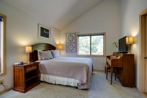 a bedroom with a bed and a desk and a television at Poplar 12 | Discover Sunriver in Sunriver