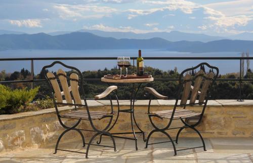 two chairs and a table with two glasses of wine at Sakali Mansion in Pinakátai