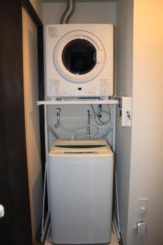 a washing machine sitting on top of a washer at Gate Inn Nago in Nago