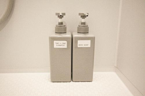 two water hydrants sitting on the floor in a bathroom at UCHI Living Stay TOYOHIRA in Sapporo