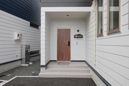 a door on the side of a building with stairs at UCHI Living Stay TOYOHIRA in Sapporo
