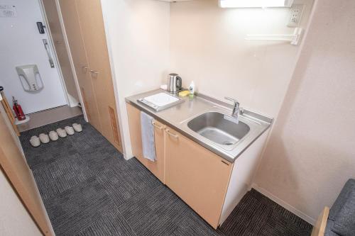 a bathroom with a sink in a room at UCHI Living Stay Otaru Suitengu in Otaru