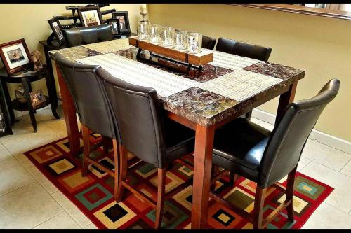 uma mesa de jantar com cadeiras pretas e uma mesa de mármore em B Private Bedroom em Orlando