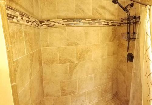 a bathroom with a shower with a tiled shower at C3 Large Private Master Room & Bath with 55" TV in Orlando
