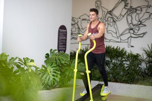 a man is standing on a yellow rope in a garden at Citadines Balestier Singapore in Singapore