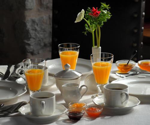 a table with glasses of orange juice and a vase of flowers at Sakali Mansion in Pinakátai