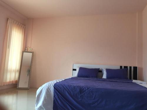 a bedroom with a bed with blue sheets and a window at Connexion in Ko Yao Noi