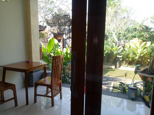 a room with a table and chairs and a window at Suryadina Guest House in Ubud