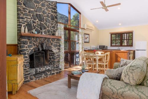 a living room with a stone fireplace at Friday Creek Retreat in Coffs Harbour