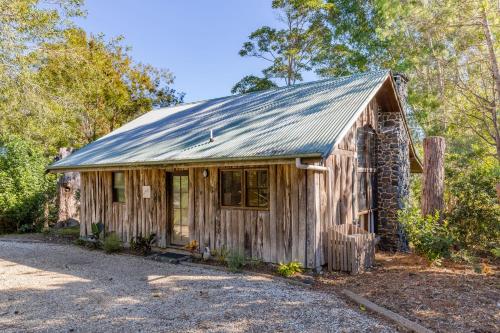 a small wooden house with a tin roof at Friday Creek Retreat in Coffs Harbour