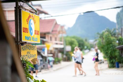 a group of people walking down a street at Pan's Place in Vang Vieng