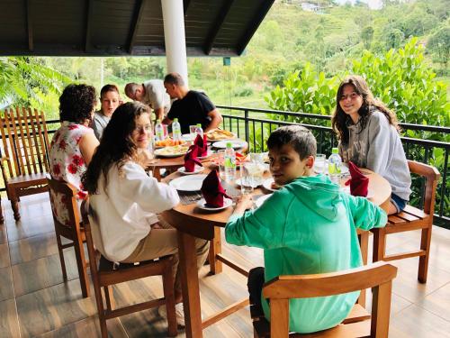 een groep mensen die rond een tafel in een restaurant zitten bij Top Mountain Resort in Diyatalawa