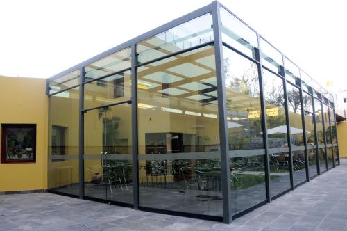 a large glass building with tables and chairs at El Cabildo Hotel in Arequipa
