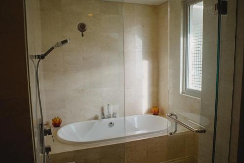 a bath tub in a bathroom with a shower at Luxury Apartment at AYANA Residences in Jimbaran