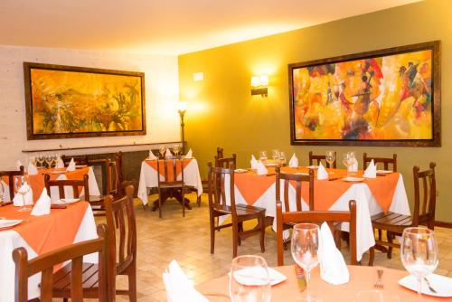 a restaurant with tables and chairs and a painting on the wall at El Cabildo Hotel in Arequipa