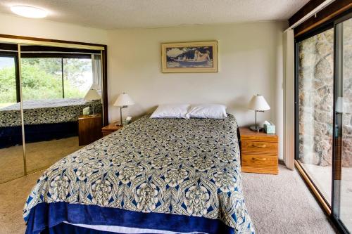 a bedroom with a bed and a large window at Paradise Regained in Len Landing