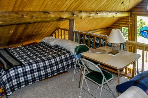 a bedroom with a bed and a desk in a cabin at Log Home on Lopez-Spencer Spit in Port Stanley