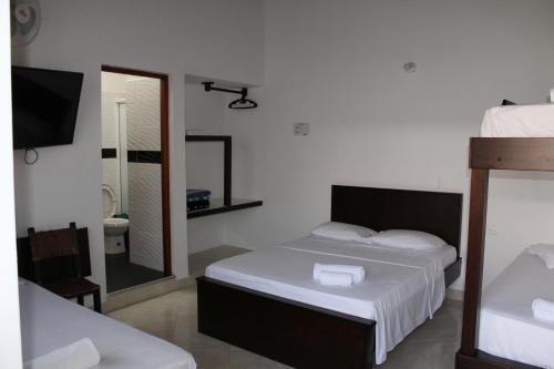 a bedroom with a bed and a bathroom with a mirror at Hotel La Ceiba in Valparaíso