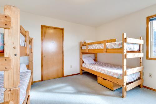 a bedroom with three bunk beds and a door at Villa VilleKulla on the Oceanfront in Oceanside