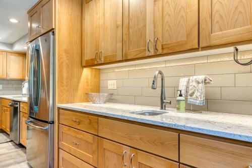 uma cozinha com armários de madeira e um lavatório em Black Butte Ranch: Hawks Beard Home em Black Butte Ranch
