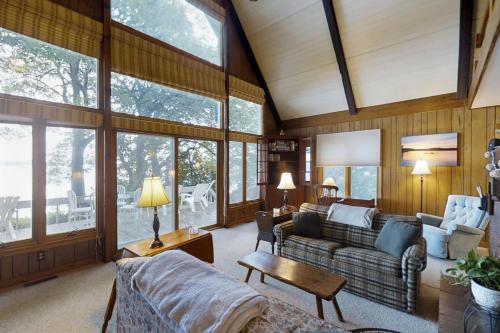un ampio soggiorno con divani e finestre di Southern Point Cottage at Inselheim Road a South Hero