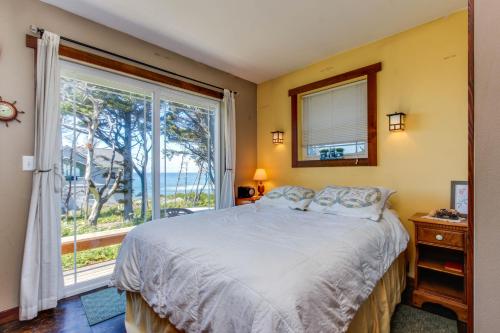 a bedroom with a bed and a large window at Oregon Bed n' Beach in Holiday Beach