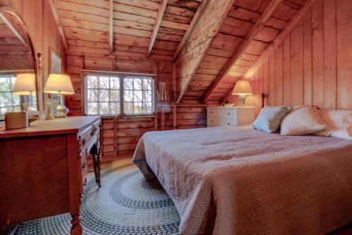 Un dormitorio con una cama en una cabaña de madera. en The 1909 Cottage, en Boothbay Harbor