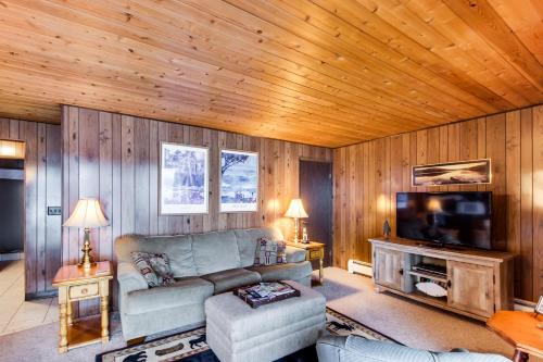 a living room with a couch and a television at Bay Point Lakefront 1B Down in Whitefish