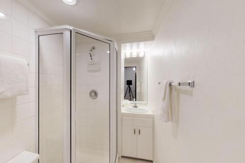 a white bathroom with a shower and a sink at Prospector Condo in Ketchum