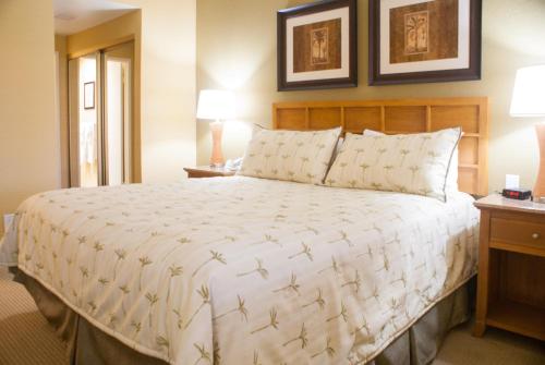 um quarto com uma cama grande e 2 candeeiros em Desert Isle Resort, a VRI resort em Palm Springs