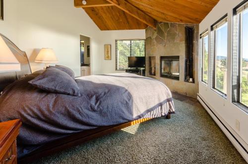 a bedroom with a large bed and a fireplace at Bovill on Shell Beach in Sea Ranch