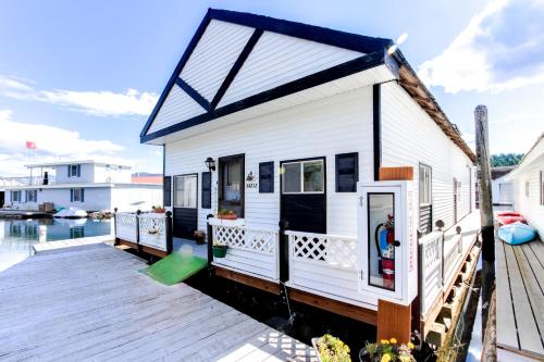a tiny house on a dock on the water at Scenic Bay Float Home Hideaway in Athol