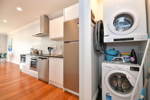 a kitchen with a washing machine and a washer at The Weiti Waterfront in Whangaparaoa