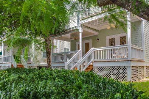 a white house with white railings and trees at Hemingway Hideaway in Stock Island