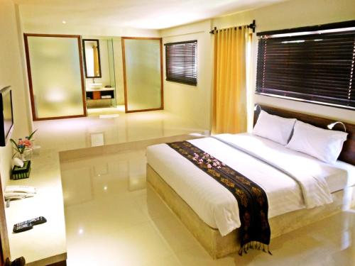 a bedroom with a large white bed in a room at The Pade Dive Resort in Sabong