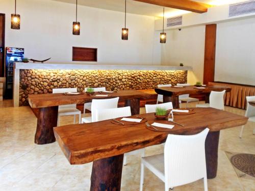 a dining room with wooden tables and white chairs at The Pade Dive Resort in Sabong