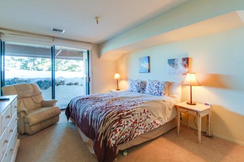 a bedroom with a bed and a chair and a window at The Bridges 102 in Mammoth Lakes
