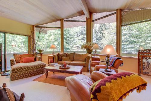 sala de estar con muebles de cuero y ventanas grandes. en Sunny Side Lodge, en Ketchum