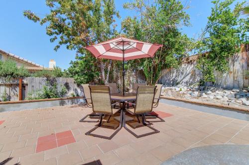 a table and chairs with an umbrella on a patio at Buttercup Delight Permit# 106,312 in Bermuda Dunes