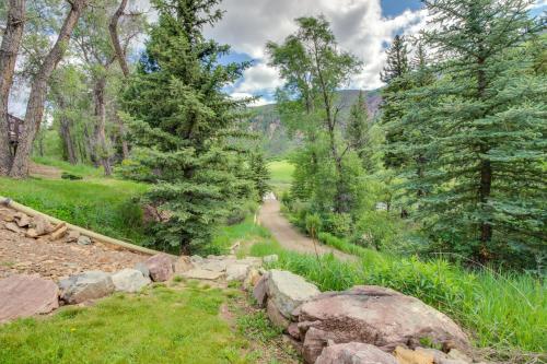 a path through a forest with trees and rocks at Chair Mountain Cabin at Filoha Meadows in Redstone